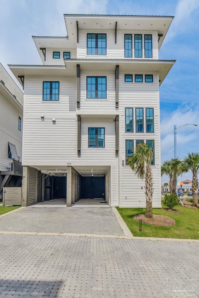 exterior space featuring a carport and decorative driveway