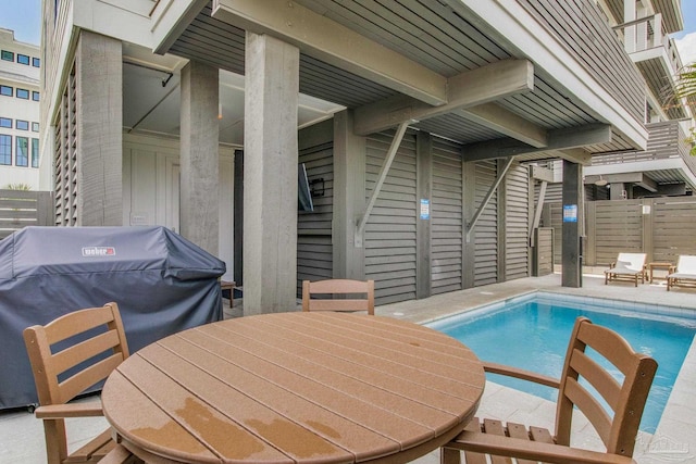 view of swimming pool featuring a fenced in pool, a patio, a grill, and outdoor dining space