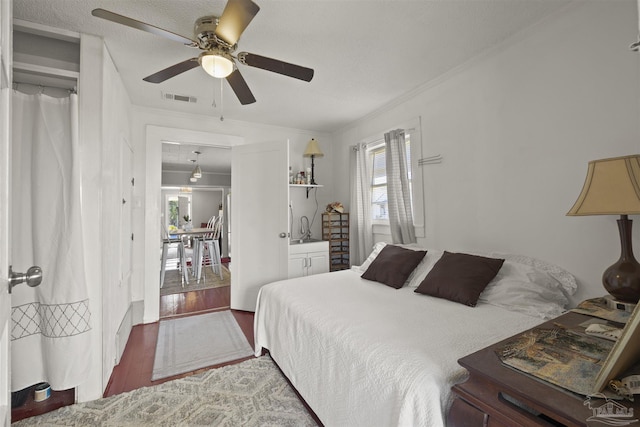 bedroom featuring crown molding, visible vents, ceiling fan, and wood finished floors