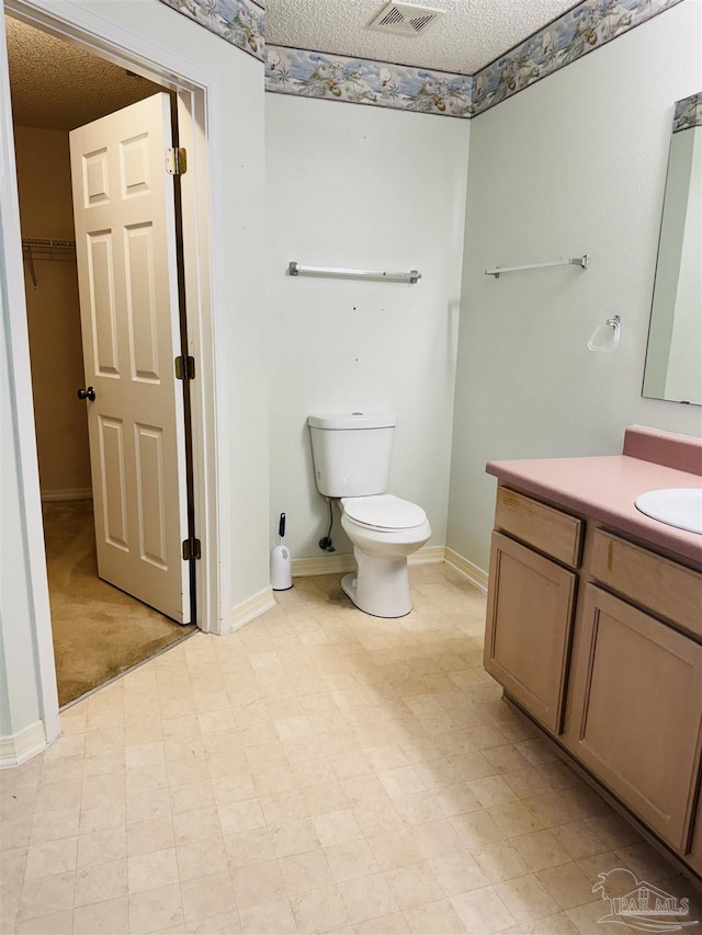 3081 Flintlock Dr, Pensacola, FL 32526 - bathroom featuring vanity, baseboards, toilet, and a textured ceiling