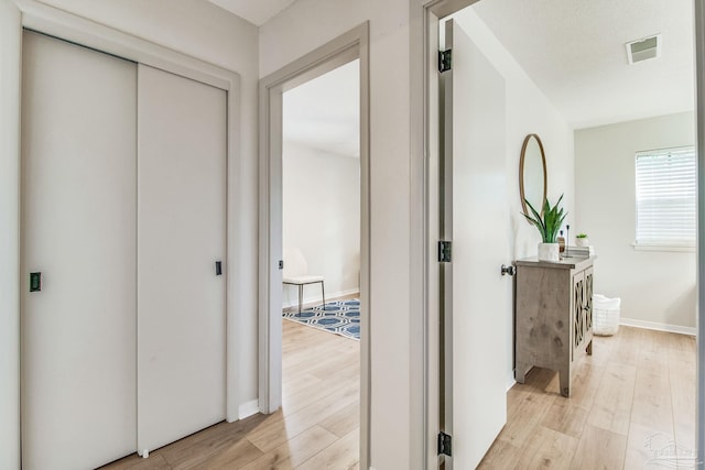 corridor with light hardwood / wood-style floors