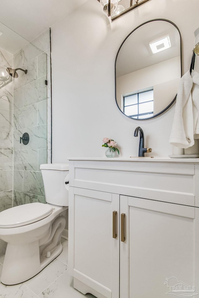 bathroom featuring vanity, toilet, and tiled shower