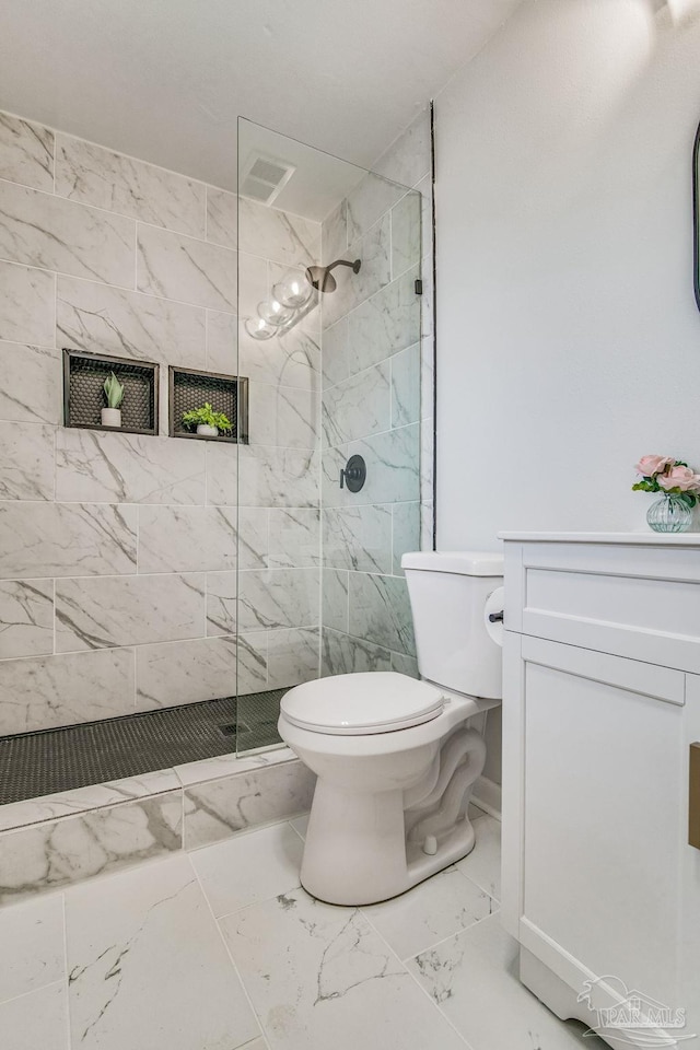 bathroom featuring toilet, walk in shower, and vanity