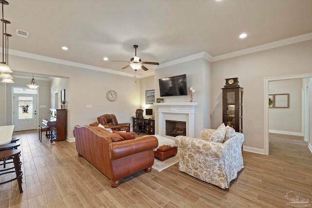 living room with crown molding, light wood-type flooring, and ceiling fan