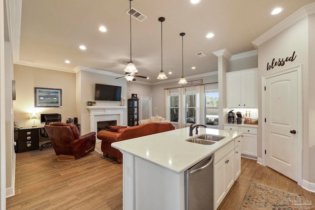 kitchen featuring sink, an island with sink, light wood-type flooring, and white cabinetry