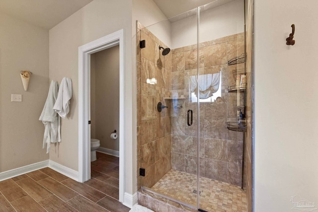 bathroom with toilet and an enclosed shower