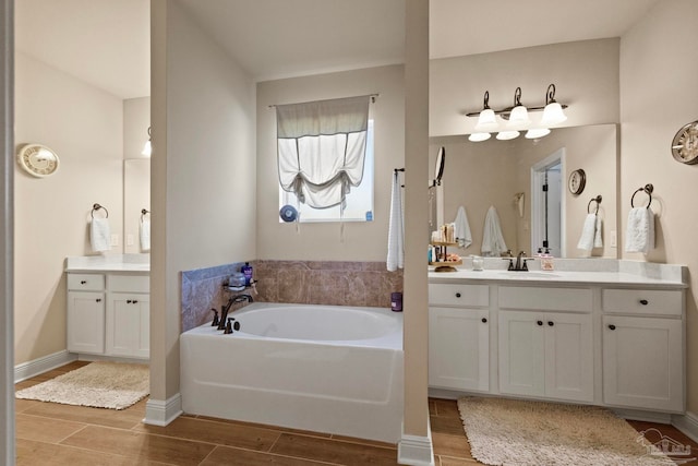 bathroom featuring vanity, a washtub, and hardwood / wood-style floors