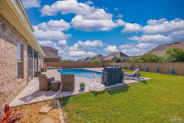 view of pool with a patio and a lawn