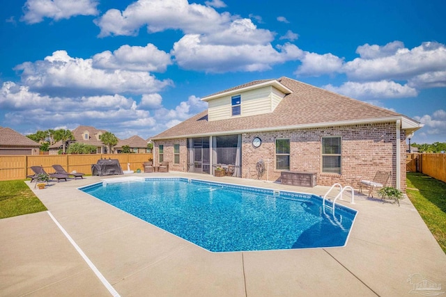 view of swimming pool with a patio and a sunroom