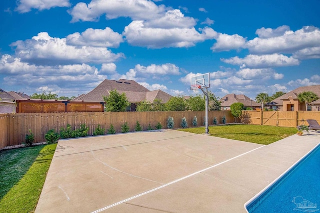 view of basketball court with a yard