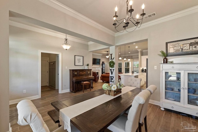 dining area featuring ornamental molding, dark wood-type flooring, and a chandelier