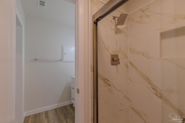 bathroom featuring visible vents, a shower stall, baseboards, and wood finished floors