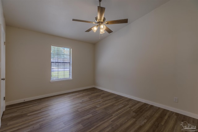 spare room with baseboards, dark wood-style floors, and a ceiling fan