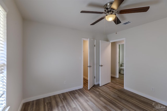 unfurnished bedroom featuring visible vents, ceiling fan, baseboards, and wood finished floors