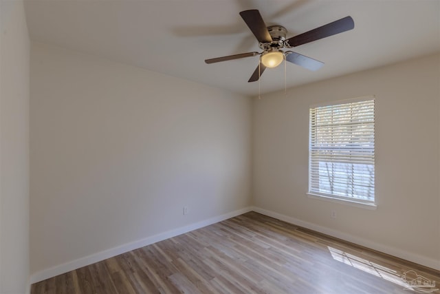 empty room featuring ceiling fan, baseboards, and wood finished floors