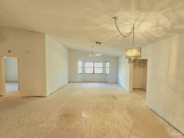 spare room featuring lofted ceiling, ceiling fan with notable chandelier, and a textured ceiling