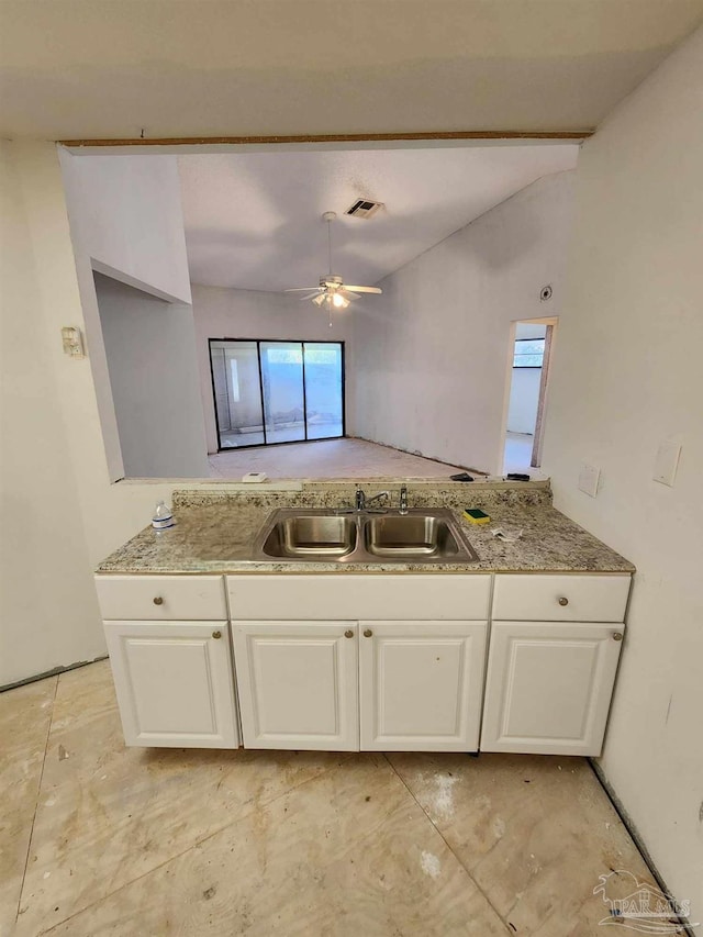 kitchen with white cabinetry, sink, plenty of natural light, and lofted ceiling