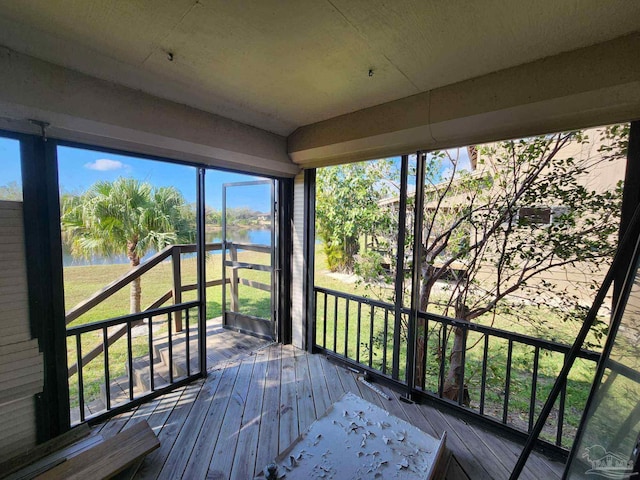 wooden terrace featuring a water view and a lawn