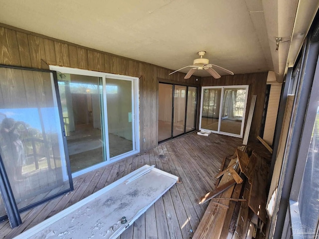 unfurnished sunroom with ceiling fan