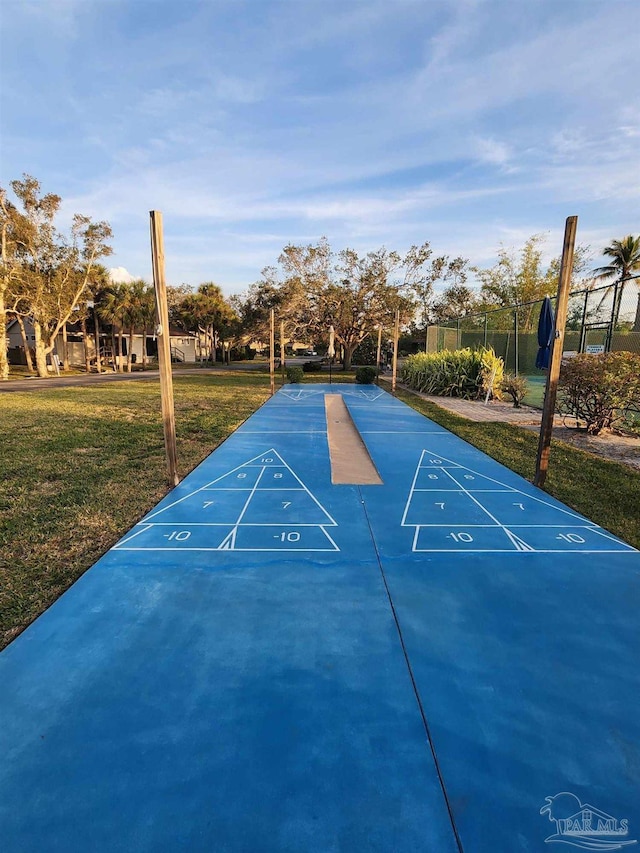 surrounding community featuring fence, shuffleboard, and a lawn