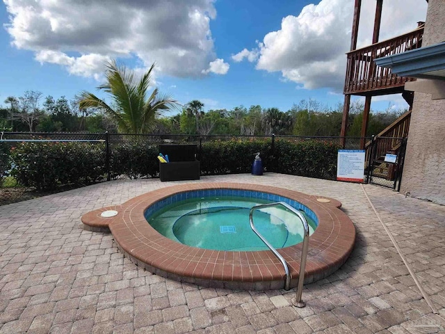 view of swimming pool featuring a hot tub