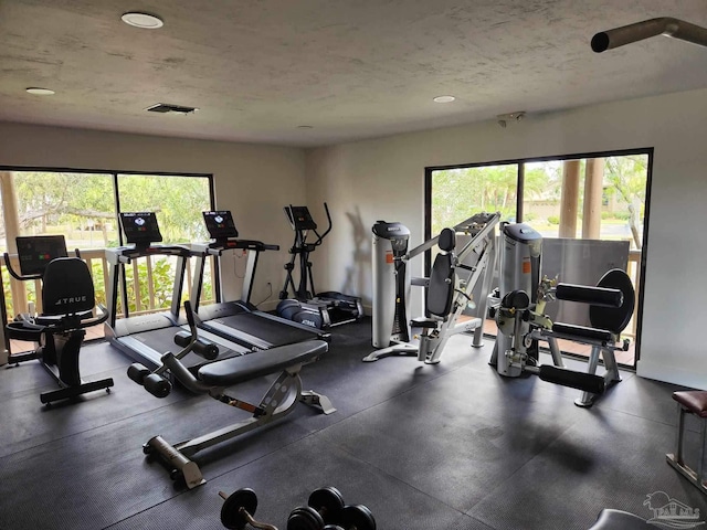 workout area featuring a textured ceiling and visible vents