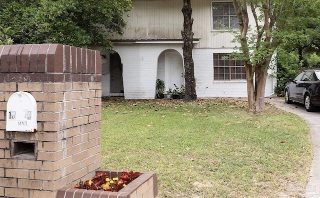 view of front of property with a front lawn and brick siding