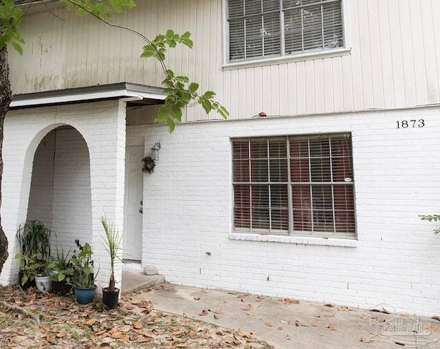 property entrance featuring brick siding