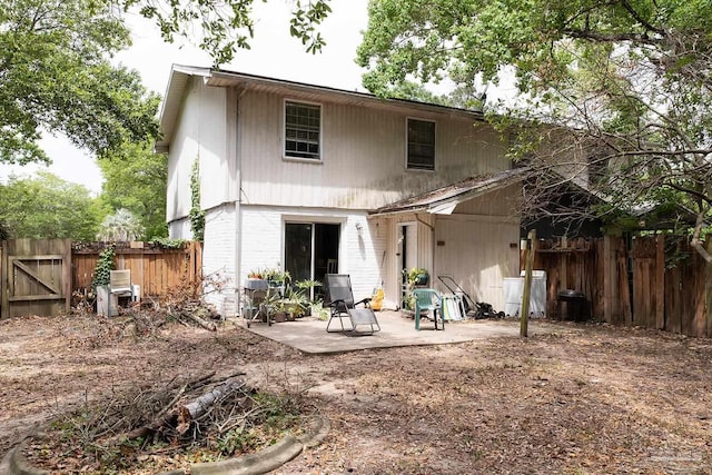 back of property featuring a fenced backyard and a patio area