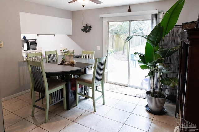 dining space with a ceiling fan and light tile patterned flooring