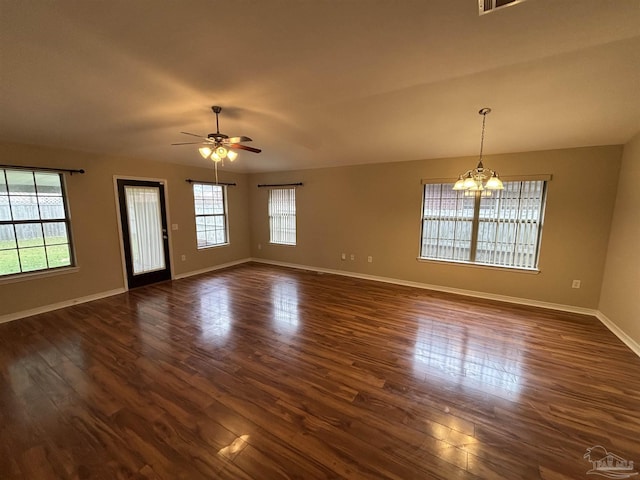 spare room with ceiling fan with notable chandelier and dark hardwood / wood-style floors