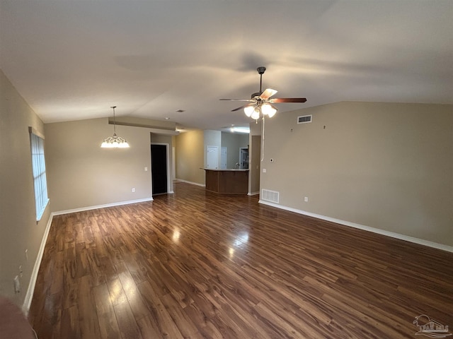 unfurnished living room featuring dark hardwood / wood-style flooring, ceiling fan with notable chandelier, and vaulted ceiling