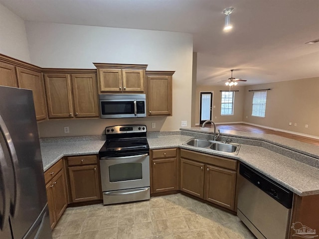 kitchen featuring kitchen peninsula, ceiling fan, sink, and stainless steel appliances