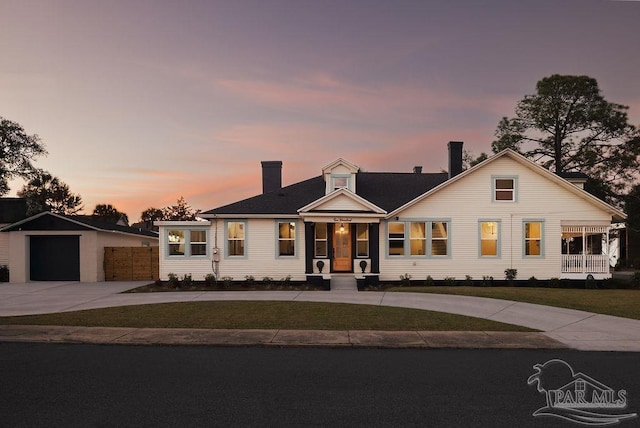 view of front facade with an outbuilding, driveway, fence, a front yard, and a garage