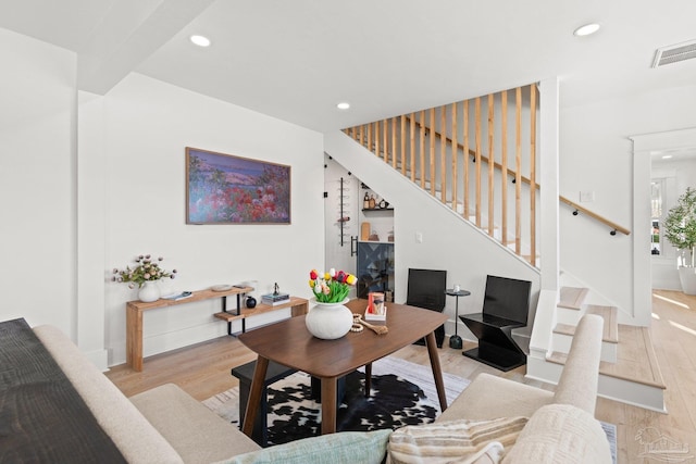 living area featuring recessed lighting, visible vents, stairway, and light wood finished floors