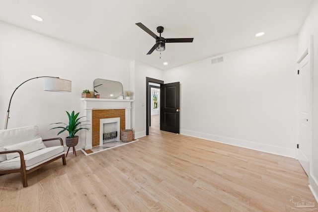 living area featuring visible vents, a fireplace with flush hearth, a ceiling fan, recessed lighting, and light wood finished floors