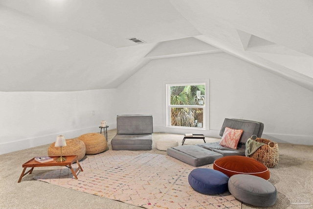 living area featuring lofted ceiling, baseboards, visible vents, and carpet floors