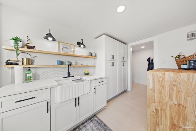 interior space with white cabinetry, open shelves, and light countertops