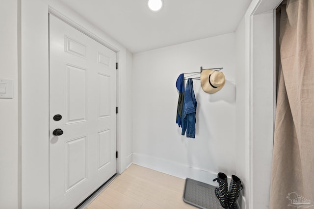 doorway to outside with baseboards and light wood-style floors