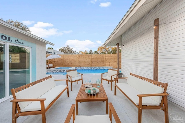 view of patio / terrace with an outdoor hangout area, a pool with connected hot tub, and fence