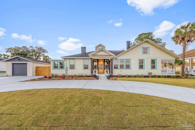 view of front of house with a front yard, concrete driveway, and a garage