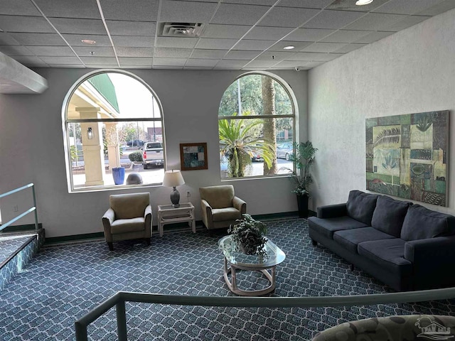 carpeted living room with a healthy amount of sunlight and a drop ceiling