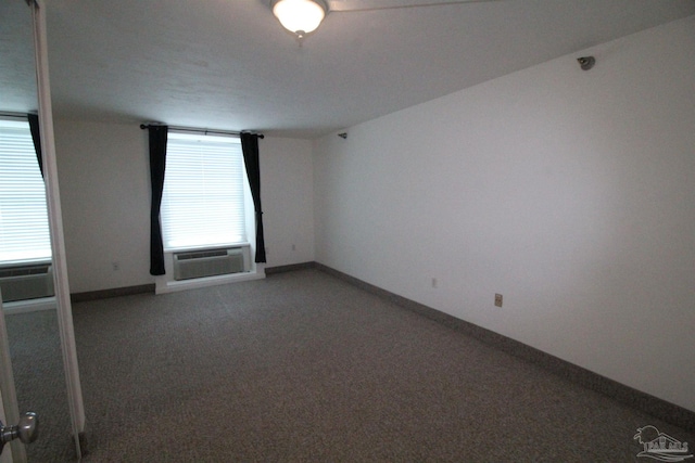 unfurnished room featuring cooling unit and carpet