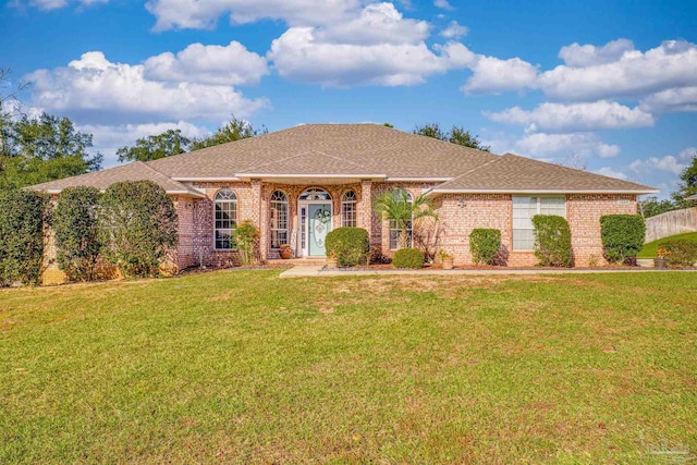 1064 Yellowstone Pass, Cantonment, FL 32533 - view of front facade featuring brick siding, a front yard, and a shingled roof