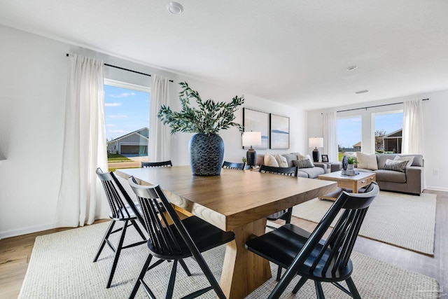 dining room with light wood-style floors and baseboards