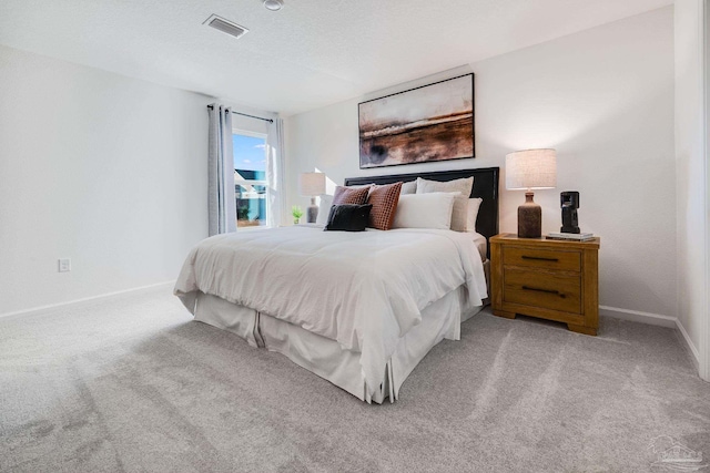 carpeted bedroom with baseboards and a textured ceiling
