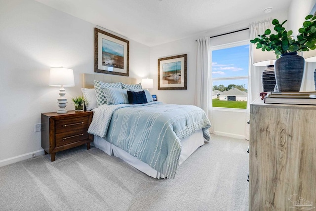 bedroom with light carpet and baseboards