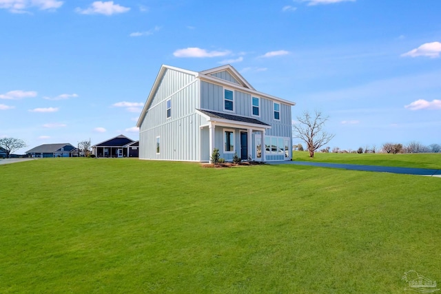 view of front of property with board and batten siding and a front lawn
