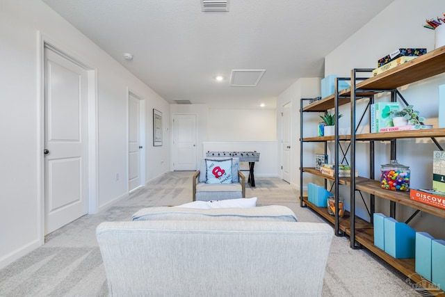 sitting room featuring light colored carpet, baseboards, and attic access