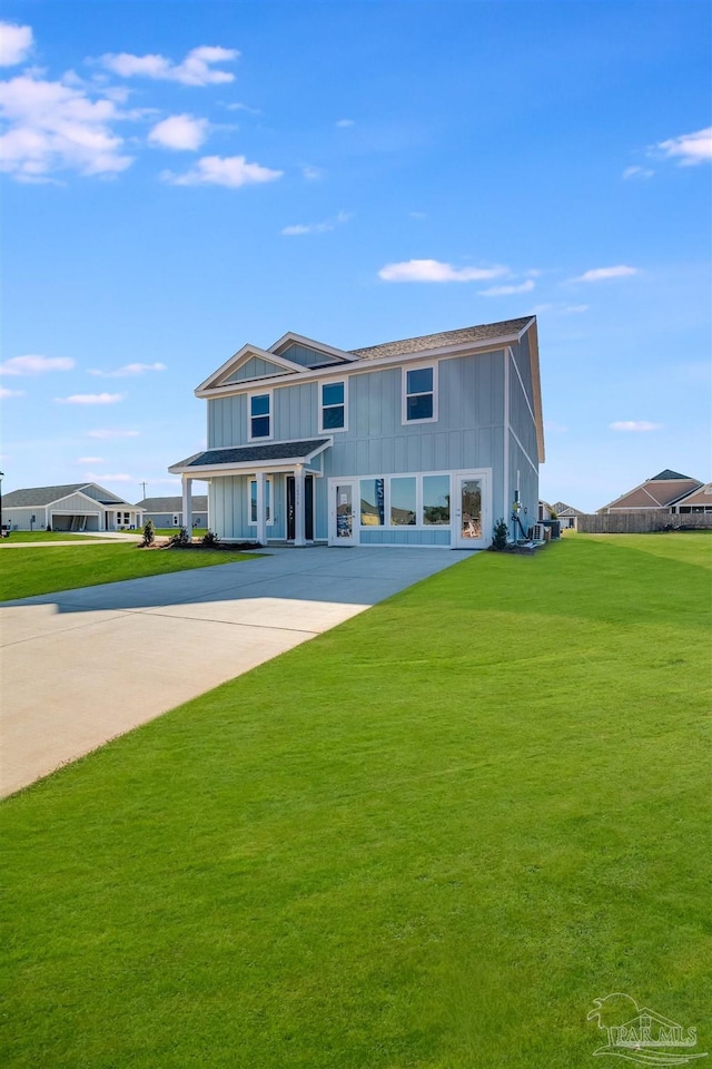 view of front facade featuring board and batten siding, a front lawn, and driveway